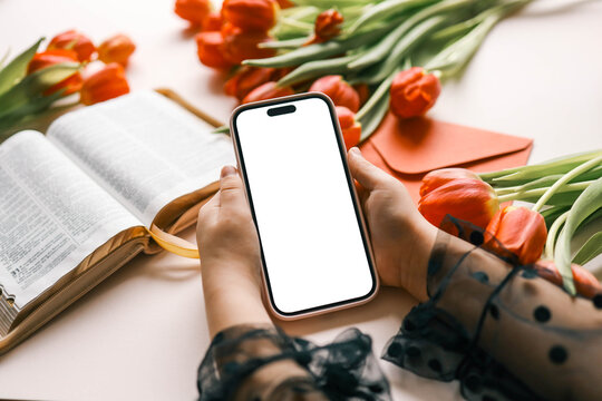 Phone with isolated screen on the background of the Bible and flowers