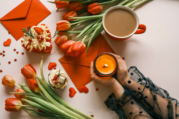 Candle and bouquet of red tulips, spring aesthetics