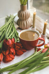 Cup of coffee, tulips and candles, spring atmosphere