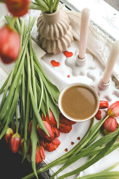 Cup of coffee, tulips and candles, spring atmosphere