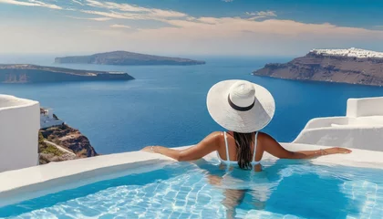 Foto auf Acrylglas Beautiful women on vacation at Santorini relaxing in swimming pool looking out over ocean.  © adobedesigner