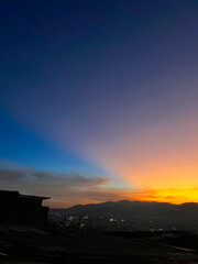 Colorful sunset with blue and orange sky. View of the city of Medellin.