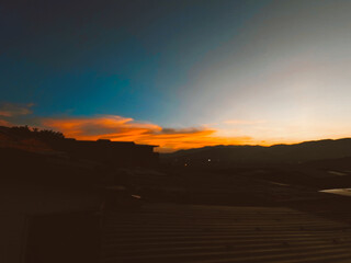 Beautiful sunset with orange sky and huge cloud seen from the Manrique neighborhood. Medellin, Antioquia, Colombia.