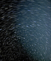 Star trails in the night sky, streaking across the background, making an interesting pattern of light.