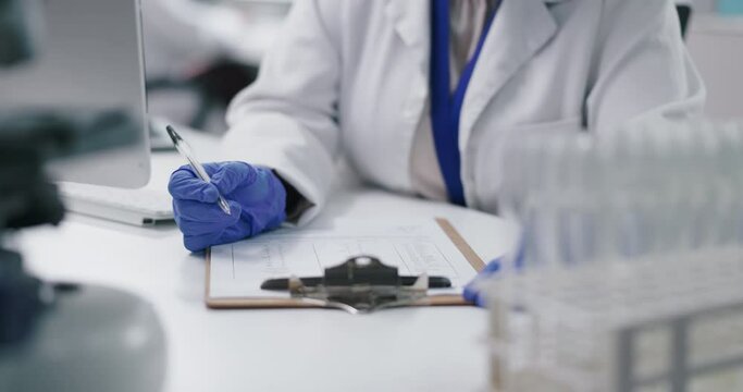 Hand, laboratory and checklist on clipboard or healthcare research for breakthrough, science or innovation. Person, fingers and pen at desk for vaccine investigation or project results, cure or form