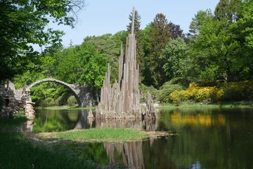 Fotobehang Rakotzbrücke Skulptur aus Säulenbasalt und Rakotzbrücke im See im Kromlauer Park