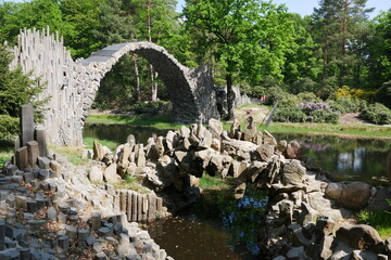 Fototapeta na wymiar Rakotzbrücke im Azaleenpark und Rhododendronpark Kromlauer Park und weitere Gartenkunst aus Säulenbasalt