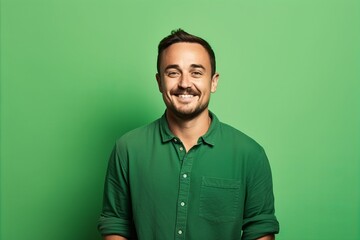 Portrait of a smiling man in a green shirt on a green background