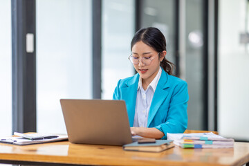 Portrait of asian young female entrepreneur sitting at her desk in the office