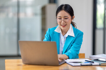 Portrait of asian young female entrepreneur sitting at her desk in the office