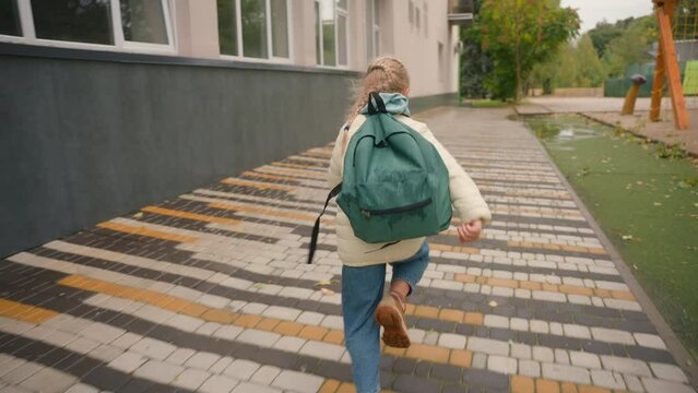 Back view little girl run quickly elementary primary school schoolgirl lessons learning education movement daughter weekend walking schoolbag junior offspring schedule child late learner city outside 