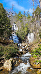 A beautiful spring landscape at Anna Ruby Falls with running water, rocks and lush green trees and...
