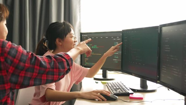 Slow motion back end software developer engineer for computer programming working together on debugging writing computing code, solving complex algorithms display on monitor in office. Burgeoning