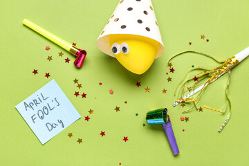 Sticker with text APRIL FOOL'S DAY, balloon and party decor on green background