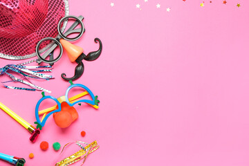 Hat with funny glasses, party whistles and decor on pink background. April Fools Day