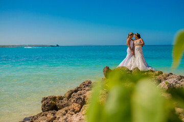 Fototapeta na wymiar pareja de mujeres casadas a orillas del mar 