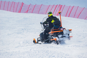Rescuer man driving snowmobile on the ski resort. - 753351331