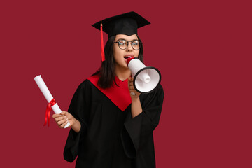 Female graduating student with diploma and megaphone on red background