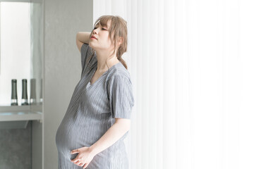 マタニティフォトの撮影をするアジア人妊婦の女性（横顔）
