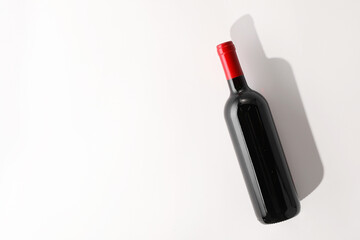 Bottle of expensive red wine on white background, top view. Space for text