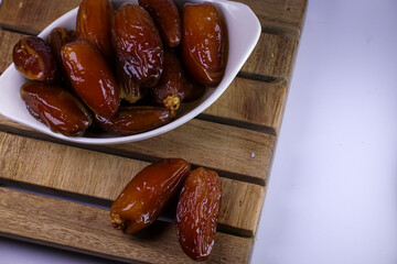 dates in a bowl on wooden table