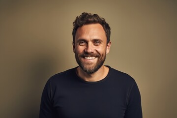 Portrait of a smiling bearded man in a black t-shirt.
