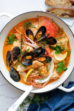 Seafood bisque in a white pot with a ladel 