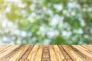 Wood table top on blur abstract green bokeh in the morning background