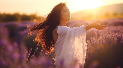 Portrait of a happy woman dancing in a lavender field at sunset