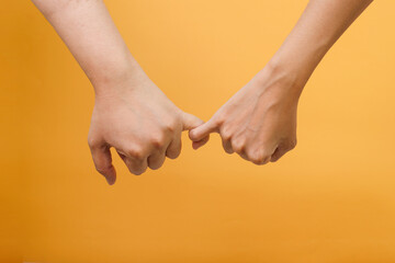 Female and male hook their little finger means promise or peace