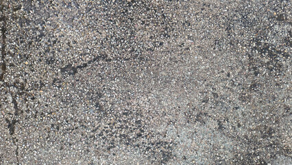 Top view of old gray cement floor with gravel stone. Concrete floor with moisture stains, lichens and moss texture or background.