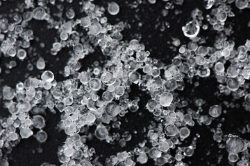 Large grains of hail on black background. Background, texture.