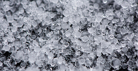 Large grains of hail on black background. Background, texture.