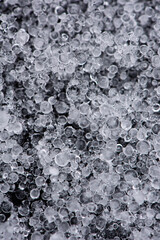 Large grains of hail on black background. Background, texture.