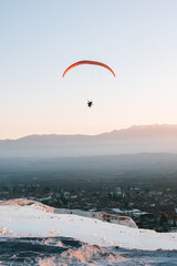 Paraglider flying over landscape sunset. Concept of extreme sport, taking adventure challenge.