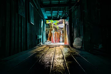 Fotobehang Gang Wooden walkway in a small alley with light shining through of Chum Saeng District  © Kobchai M.