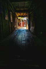 Fotobehang Gang Wooden walkway in a small alley with light shining through of Chum Saeng District  © Kobchai M.