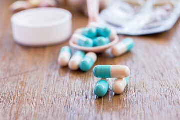 Selective focus on pill spread on wooden background.
