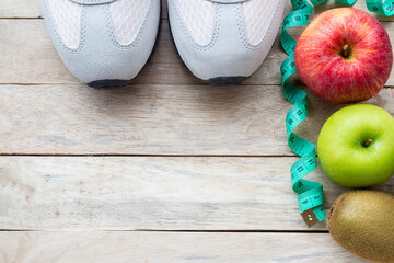 Top view shoe,measuring tape and apple on wood table background