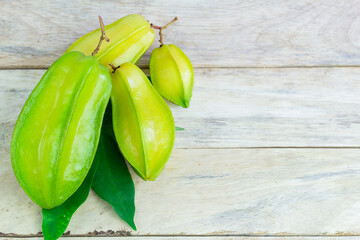 Close up star fruit carambola or star apple ( starfruit ) on wood table background. Star fruit with healthy food.