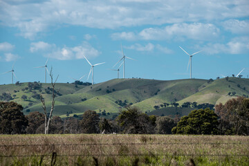 wind turbines farm on greens hills  with blur sky and white clouds