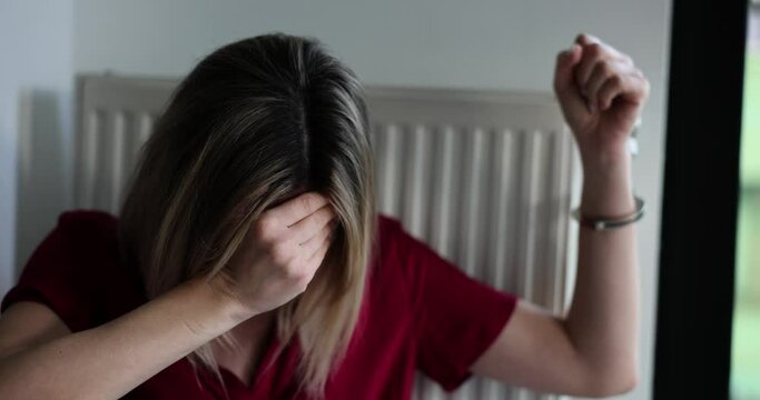 Upset kidnapped woman handcuffed to heating radiator cries