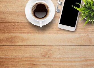 Fototapeta na wymiar Smart phone and earphone with cup of coffee on old wooden background