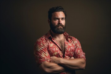 Portrait of a handsome bearded man in a red shirt on a dark background