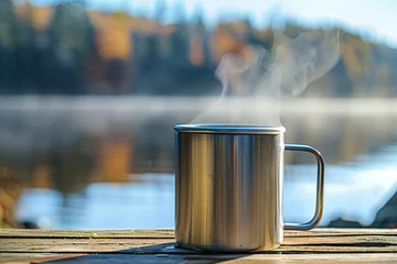 Fototapeten Metal mug with hot tea on a wooden table near the lake and autumn forest © Aleksandr Bryliaev