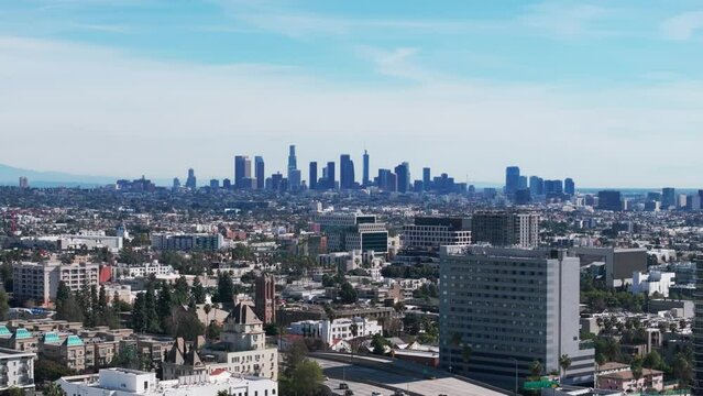 Telephoto drone shot of the los angeles skyline during a sunny day panning left