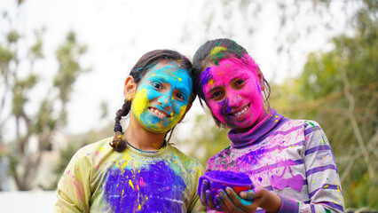 Happy Cute Indian kids applying colours on each other on the occasion of colors festival holi