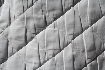 Close up of white quilted fabric textured background