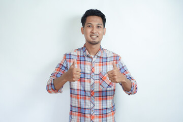 Fototapeta premium Adult Asian man showing cheerful expression and give two thumbs up