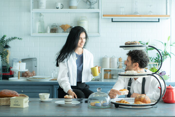 A husband wears an apron while cooking dinner with his wife. The duo took a break to sip coffee and...